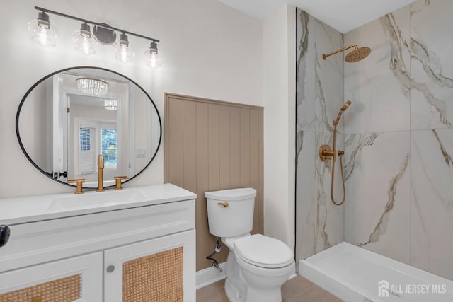full bathroom featuring toilet, tile patterned floors, a marble finish shower, and vanity