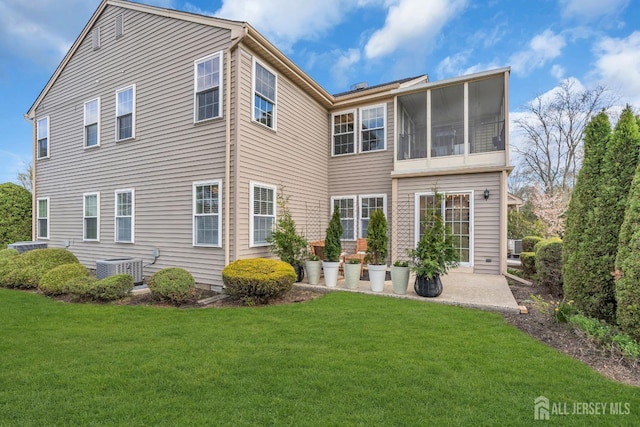 rear view of property featuring a yard, central air condition unit, and a patio
