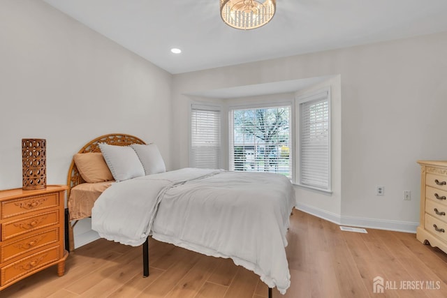 bedroom with recessed lighting, an inviting chandelier, light wood-type flooring, visible vents, and baseboards