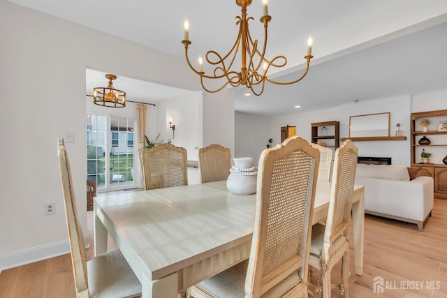 dining room with light wood-style flooring, a large fireplace, baseboards, recessed lighting, and a notable chandelier