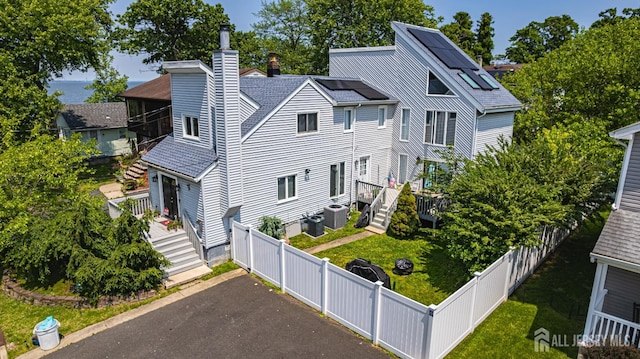 76 Woodland Dr, Keyport, NJ 07735 - view of front of property featuring a chimney, a wooden deck, cooling unit, roof with shingles, and driveway