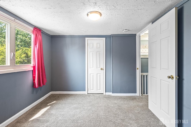 76 Woodland Dr, Keyport, NJ 07735 - unfurnished bedroom featuring carpet, baseboards, a textured ceiling, and a closet