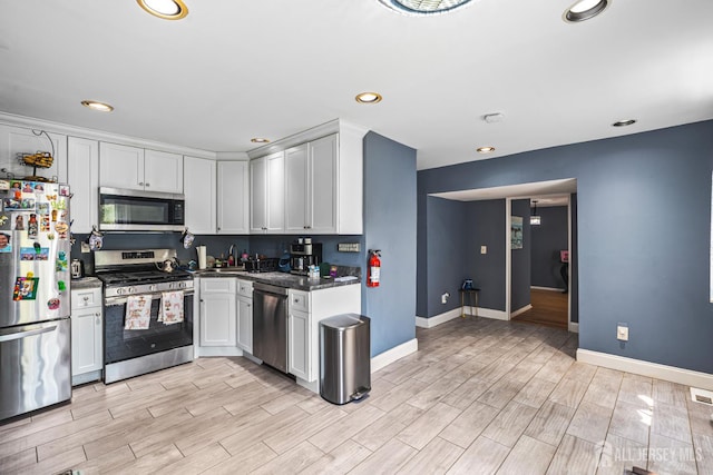 76 Woodland Dr, Keyport, NJ 07735 - kitchen featuring stainless steel appliances, baseboards, dark countertops, light wood-style flooring, and recessed lighting