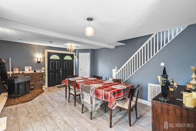 76 Woodland Dr, Keyport, NJ 07735 - dining room featuring a wood stove, wood finished floors, stairs, and baseboards
