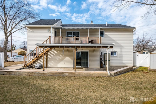 back of house featuring a patio, a lawn, stairway, a gate, and fence