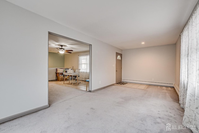 carpeted empty room featuring a baseboard radiator, a ceiling fan, and baseboards