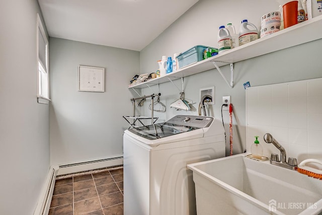 laundry area featuring laundry area, a sink, baseboard heating, tile patterned floors, and washing machine and clothes dryer