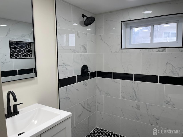 full bathroom with vanity and a tile shower