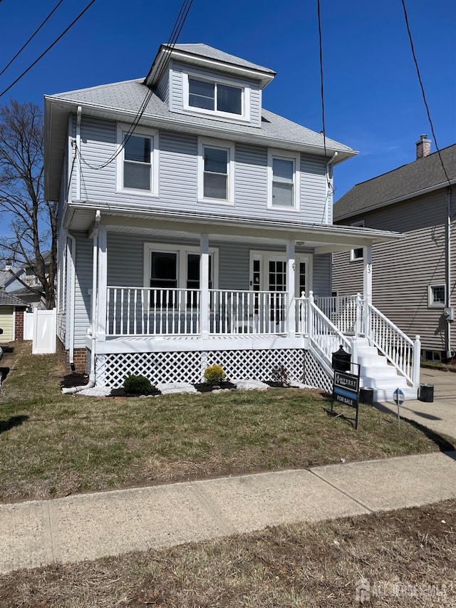 traditional style home featuring covered porch and a front lawn