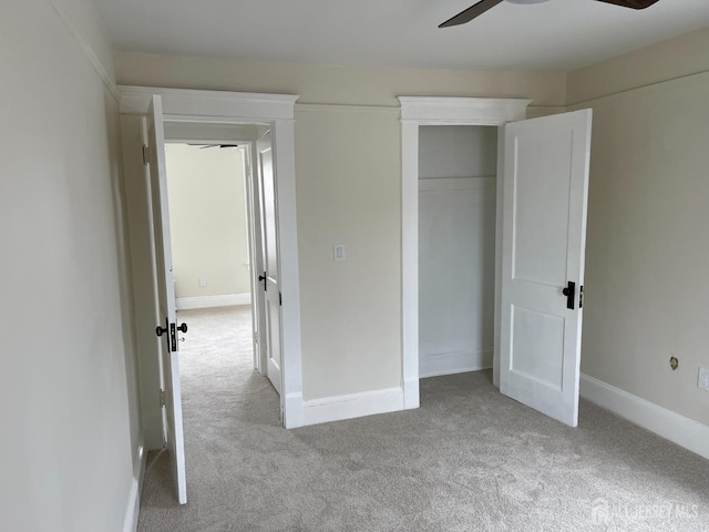 unfurnished bedroom with baseboards, carpet flooring, a closet, and ceiling fan