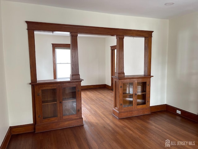 spare room featuring wood finished floors and baseboards