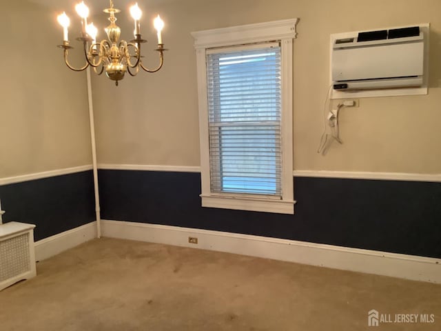 unfurnished dining area featuring an AC wall unit, carpet flooring, baseboards, and an inviting chandelier