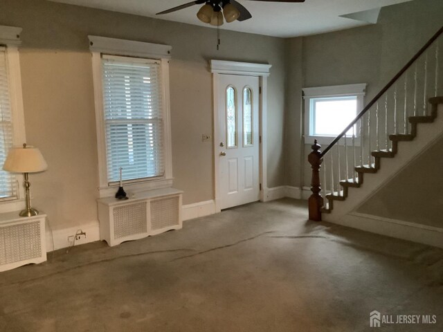 carpeted entrance foyer with radiator and ceiling fan