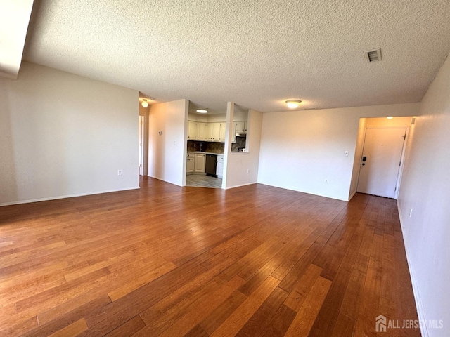 unfurnished living room with visible vents, hardwood / wood-style flooring, and a textured ceiling