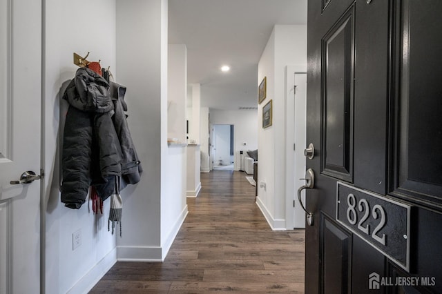 hall with dark wood-type flooring, baseboards, and recessed lighting