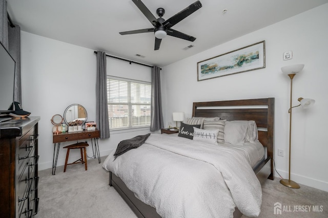 bedroom featuring visible vents, baseboards, a ceiling fan, and light carpet