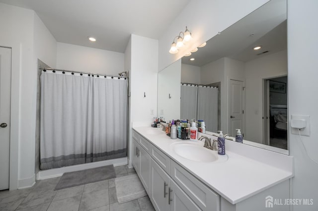 bathroom with double vanity, a sink, visible vents, and recessed lighting