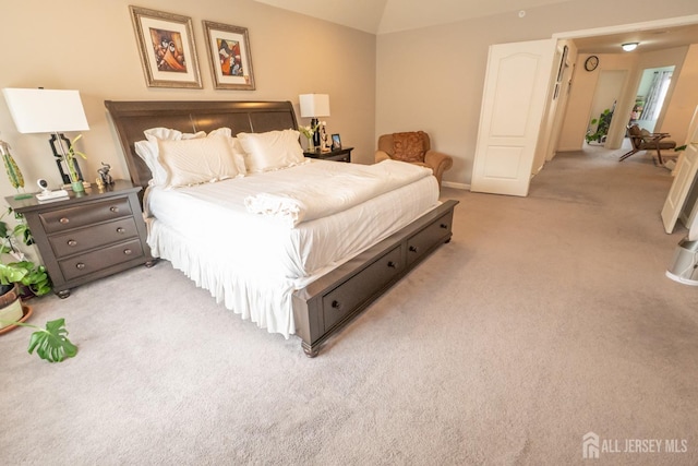 bedroom featuring lofted ceiling and light colored carpet