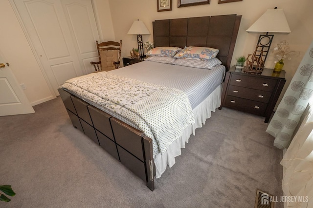 carpeted bedroom with visible vents and a closet