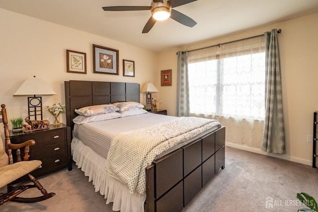 bedroom featuring light carpet, a ceiling fan, and baseboards