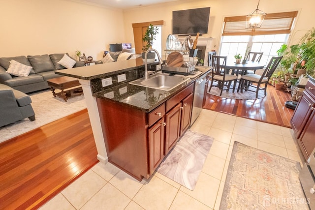 kitchen featuring open floor plan, light tile patterned floors, plenty of natural light, and a sink