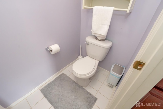 bathroom with toilet, baseboards, and tile patterned floors