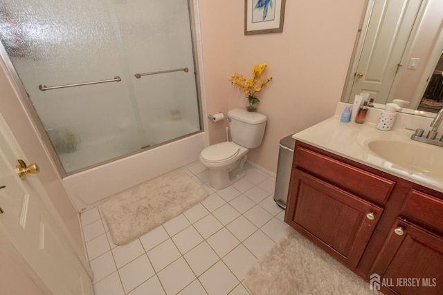 full bath with combined bath / shower with glass door, vanity, toilet, and tile patterned floors