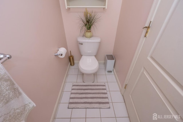 bathroom with baseboards, toilet, and tile patterned floors