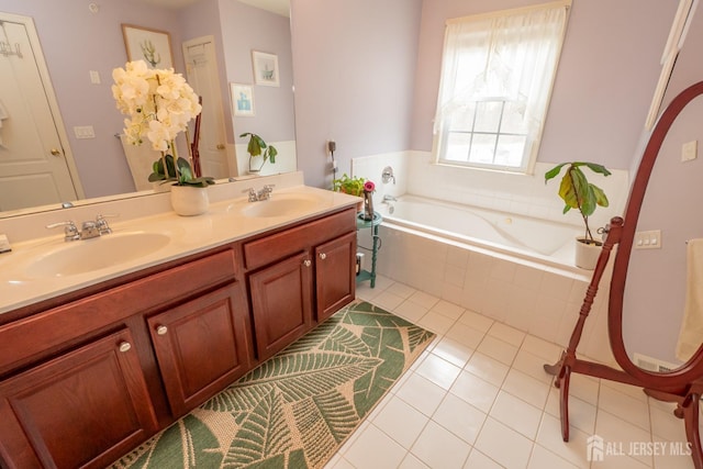 bathroom with a garden tub, double vanity, a sink, and tile patterned floors