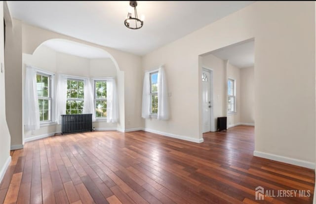 5 Warren St, Jamesburg, NJ 08831 - unfurnished living room with radiator, hardwood / wood-style floors, and arched walkways