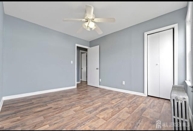 5 Warren St, Jamesburg, NJ 08831 - unfurnished bedroom with radiator, wood finished floors, a closet, and a ceiling fan
