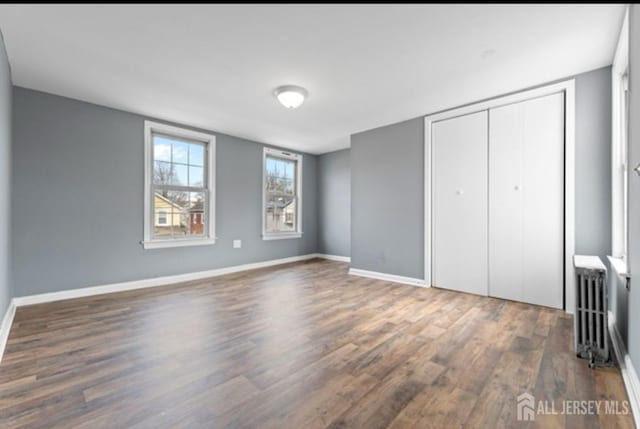 5 Warren St, Jamesburg, NJ 08831 - unfurnished bedroom with radiator heating unit, wood finished floors, and a closet