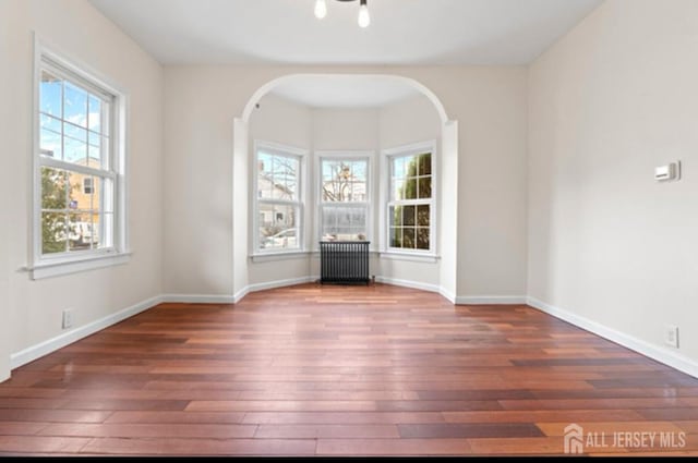 5 Warren St, Jamesburg, NJ 08831 - spare room with radiator, hardwood / wood-style flooring, and arched walkways