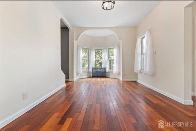 5 Warren St, Jamesburg, NJ 08831 - unfurnished living room featuring dark wood finished floors, arched walkways, and radiator