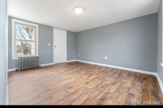 5 Warren St, Jamesburg, NJ 08831 - unfurnished bedroom featuring radiator heating unit and wood finished floors