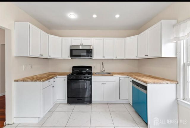 5 Warren St, Jamesburg, NJ 08831 - kitchen with stainless steel microwave, black gas range, dishwashing machine, light countertops, and white cabinetry