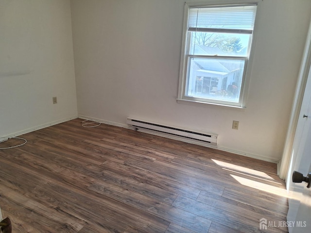 empty room with baseboards, dark wood-type flooring, and baseboard heating