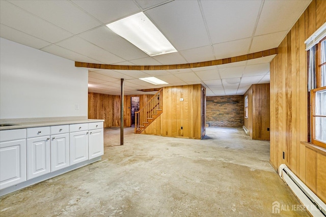 730 Old Post Rd, Edison, NJ 08817 - below grade area with a baseboard heating unit, wood walls, stairway, a drop ceiling, and a baseboard radiator