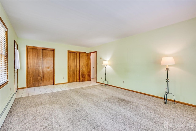 730 Old Post Rd, Edison, NJ 08817 - unfurnished bedroom with multiple closets, a baseboard radiator, light colored carpet, and light tile patterned flooring