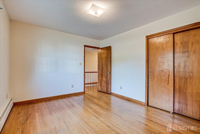 730 Old Post Rd, Edison, NJ 08817 - unfurnished bedroom with baseboard heating, light wood finished floors, and a closet