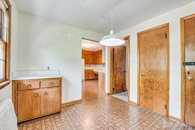 730 Old Post Rd, Edison, NJ 08817 - kitchen featuring freestanding refrigerator, light countertops, brown cabinetry, and hanging light fixtures