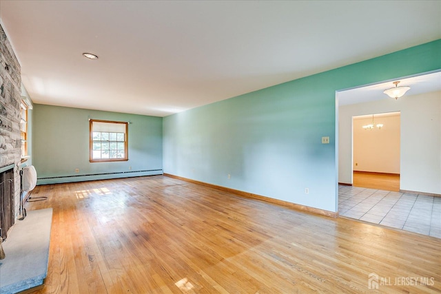 730 Old Post Rd, Edison, NJ 08817 - unfurnished living room with baseboard heating, a chandelier, a fireplace, and wood finished floors