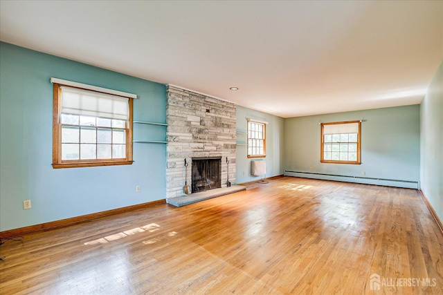 730 Old Post Rd, Edison, NJ 08817 - unfurnished living room with baseboard heating, wood finished floors, and a stone fireplace