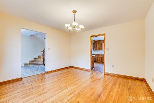 730 Old Post Rd, Edison, NJ 08817 - empty room with a chandelier, light wood finished floors, and stairs