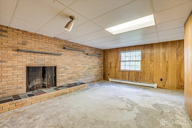 730 Old Post Rd, Edison, NJ 08817 - unfurnished living room featuring a baseboard radiator, a fireplace, a paneled ceiling, wooden walls, and concrete flooring