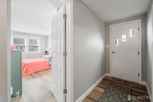 foyer entrance with light wood finished floors and baseboards