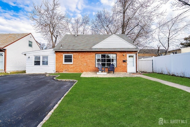 rear view of house with brick siding, fence, a yard, crawl space, and a patio