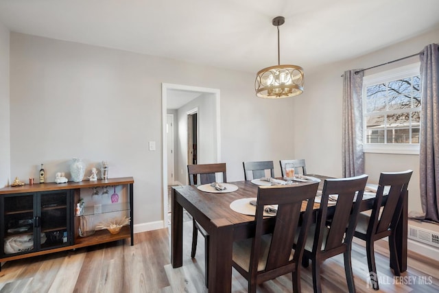 dining space with visible vents, baseboards, an inviting chandelier, and wood finished floors