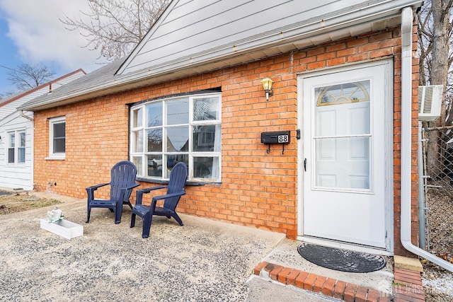 view of exterior entry featuring brick siding