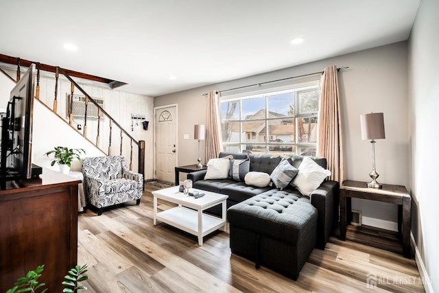 living room with light wood finished floors, recessed lighting, and stairs